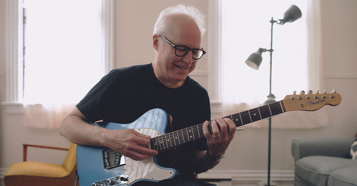 A man playing his guitar.